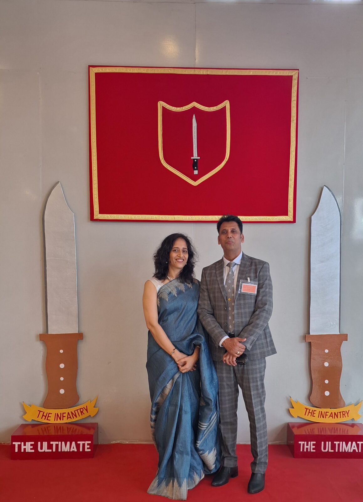 Capt. Prabhu in a grey suit before an Indian Army Infantry insignia.