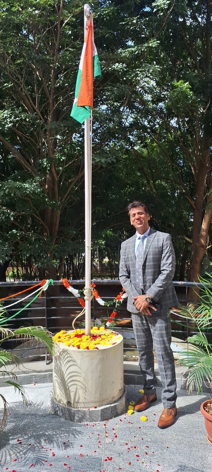 Capt. Prabhu beside a flagpole with the Indian flag.